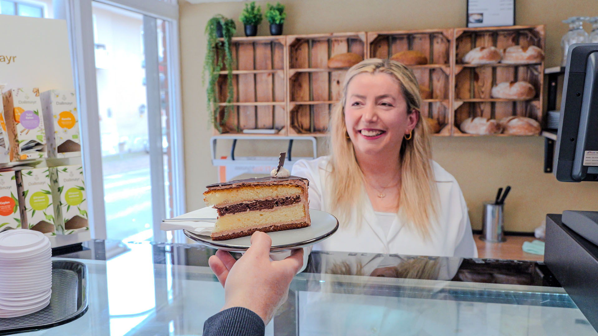 Frau gibt Kuchen über die Theke